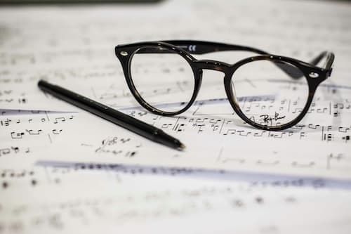 glasses and a pen left on sheet music